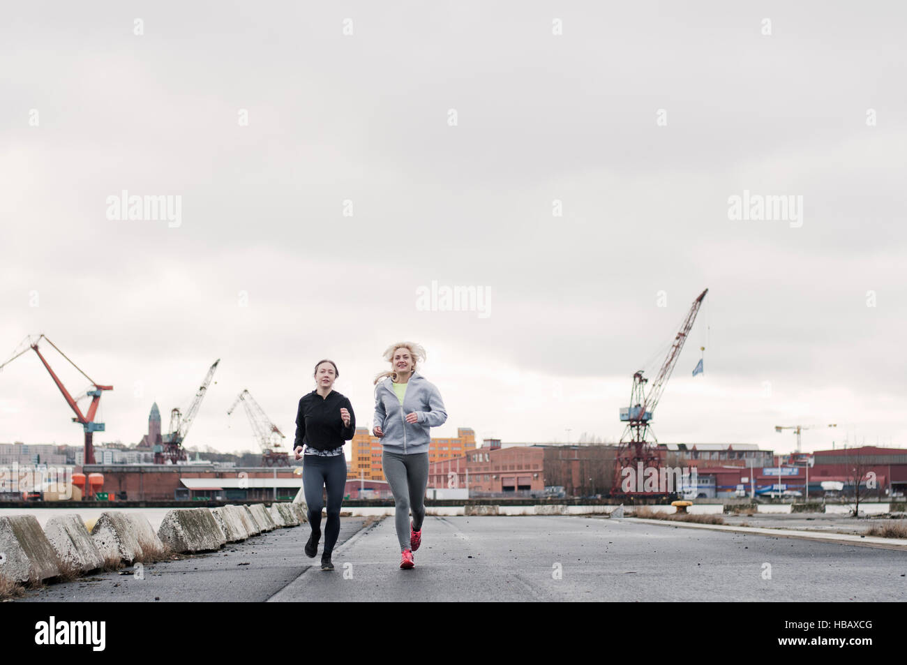 Zwei Freundinnen laufen entlang am Hafen Stockfoto