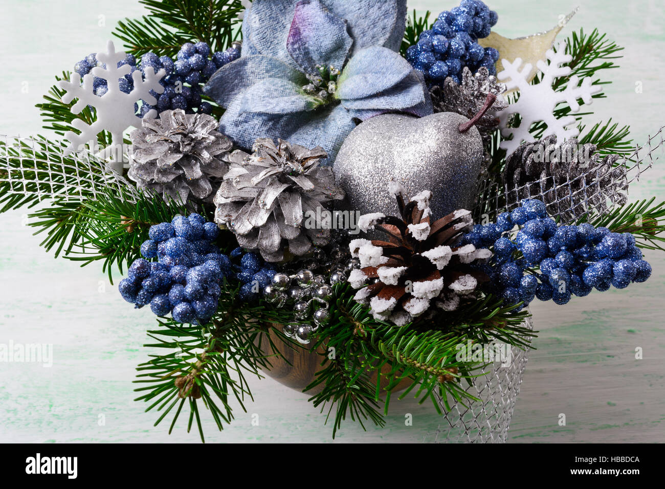 Weihnachten Hintergrund mit blauer Seide Weihnachtssterne und Glitzer Beeren. Künstliche Blume Weihnachtsarrangement mit Tannenzapfen und Tannenzweigen. Urlaub Stockfoto