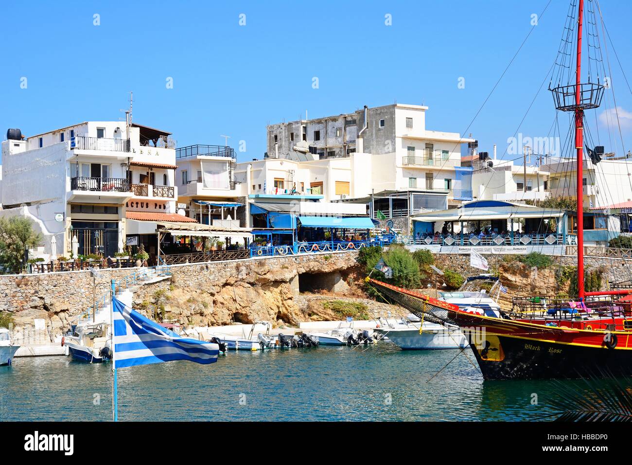 Black Rose Piratenschiff vor Anker im Hafen mit Restaurants am Wasser nach hinten, Sissi, Kreta, Europa. Stockfoto