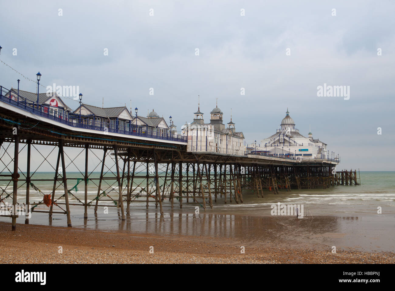 Eastbourne, England - 20. Mai. 2012. Berühmte Eastbourne Pier und Strand im bewölkten Tag. East Sussex, England, UK. Eastbourne ist eine große Stadt, am Meer resor Stockfoto