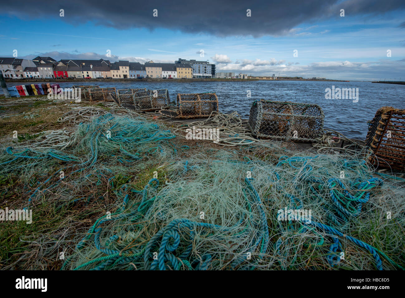 Fischernetze und Hummer Käfigen am Claddagh in Galway. Bunte Häuser im Hintergrund. Stockfoto