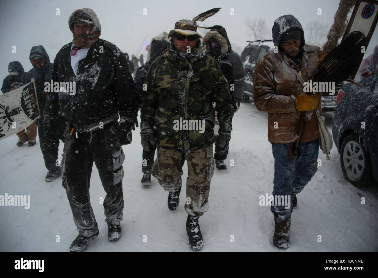 Kanonenkugel, North Dakota, USA. 5. Dezember 2016. JEFF PARKER von der 82. US-Luftlandedivision (links), BRENT hohe Elch ein 12-Jahres-Veteran (Mitte) und GLEN SCOTT vom Stamm Chippewa in Wisconsin (rechts) Marsch zurück auf Lager mit Wasser Protektoren nach einem Spaziergang in Richtung Barrikaden auf der Autobahn 1806 mit Unterstützung von US-Militärs im Ruhestand an der Standing Rock Indian Reservation in Kanonenkugel, North Dakota. Der Marsch fand am selben Tag, dass Gouverneur von North Dakota Jack Dalrymple Bestellung zu den Oceti Sakowin Camp evakuieren wirksam werden. © Joel Angel Ju'' ¡Rez/ZUMA Draht/Alamy Live-Nachrichten Stockfoto