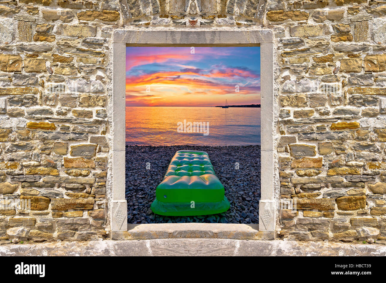 Sonnenuntergang am Strand durch Steinmauer Tür Stockfoto