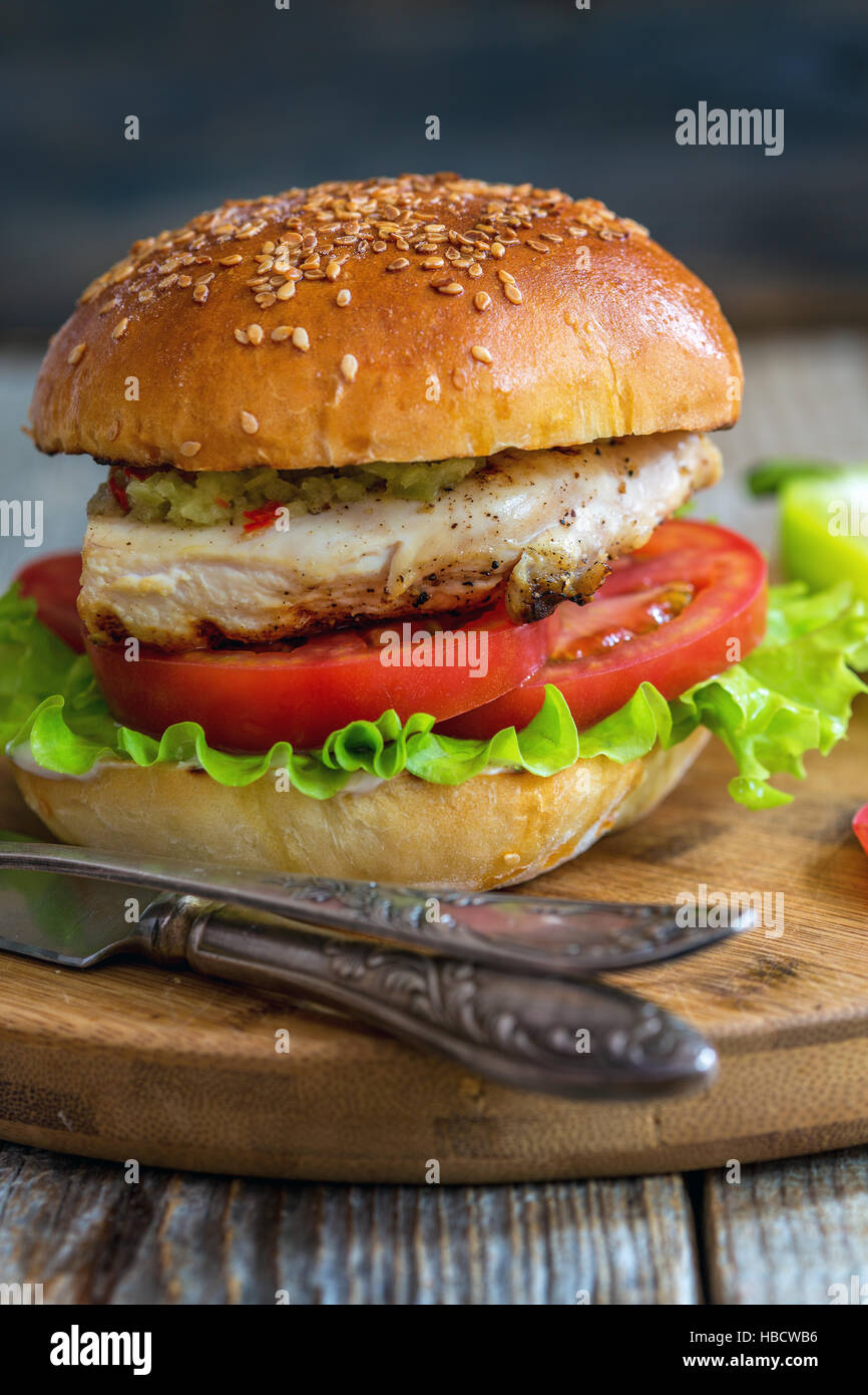 Burger mit Hähnchen, scharfer Sauce und Salat. Stockfoto