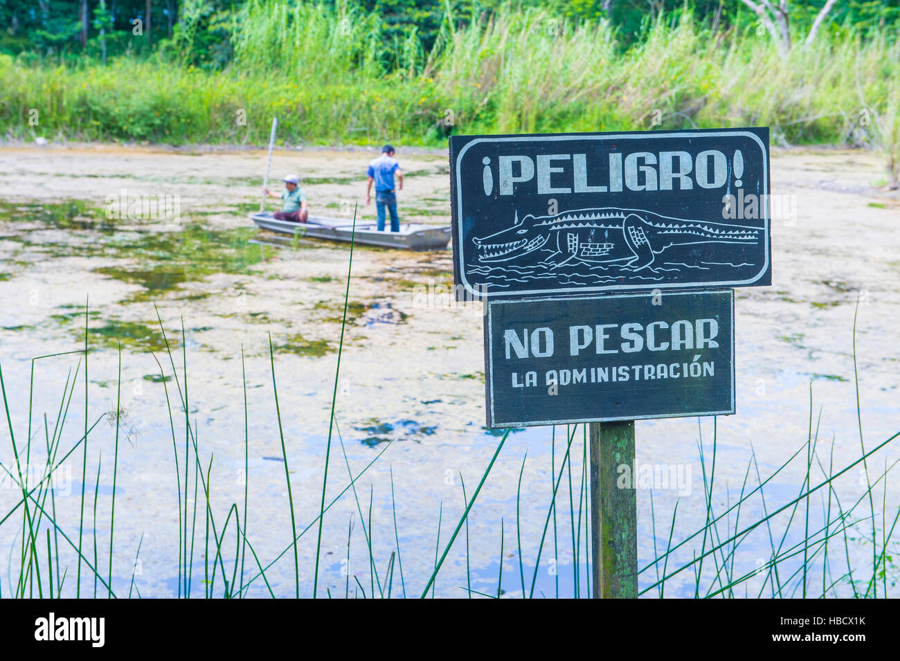 Krokodil-Warnschild in der Nähe von einem künstlichen Teich im Nationalpark Tikal Guatemala. Der Teich wurde von der Mayas für die Sammlung von Regenwasser Stockfoto