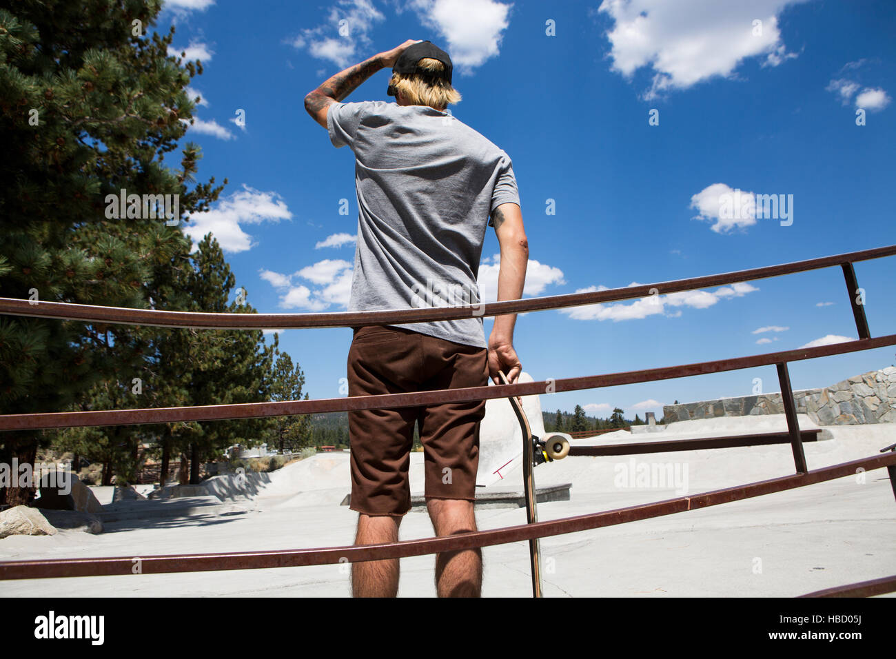 Rückansicht des jungen männlichen Skateboarder Blick auf Skate-Park, Mammoth Lakes, Kalifornien, USA Stockfoto