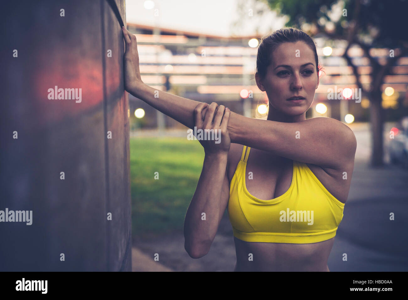 Junge Frau, stretching, Wand gelehnt Stockfoto