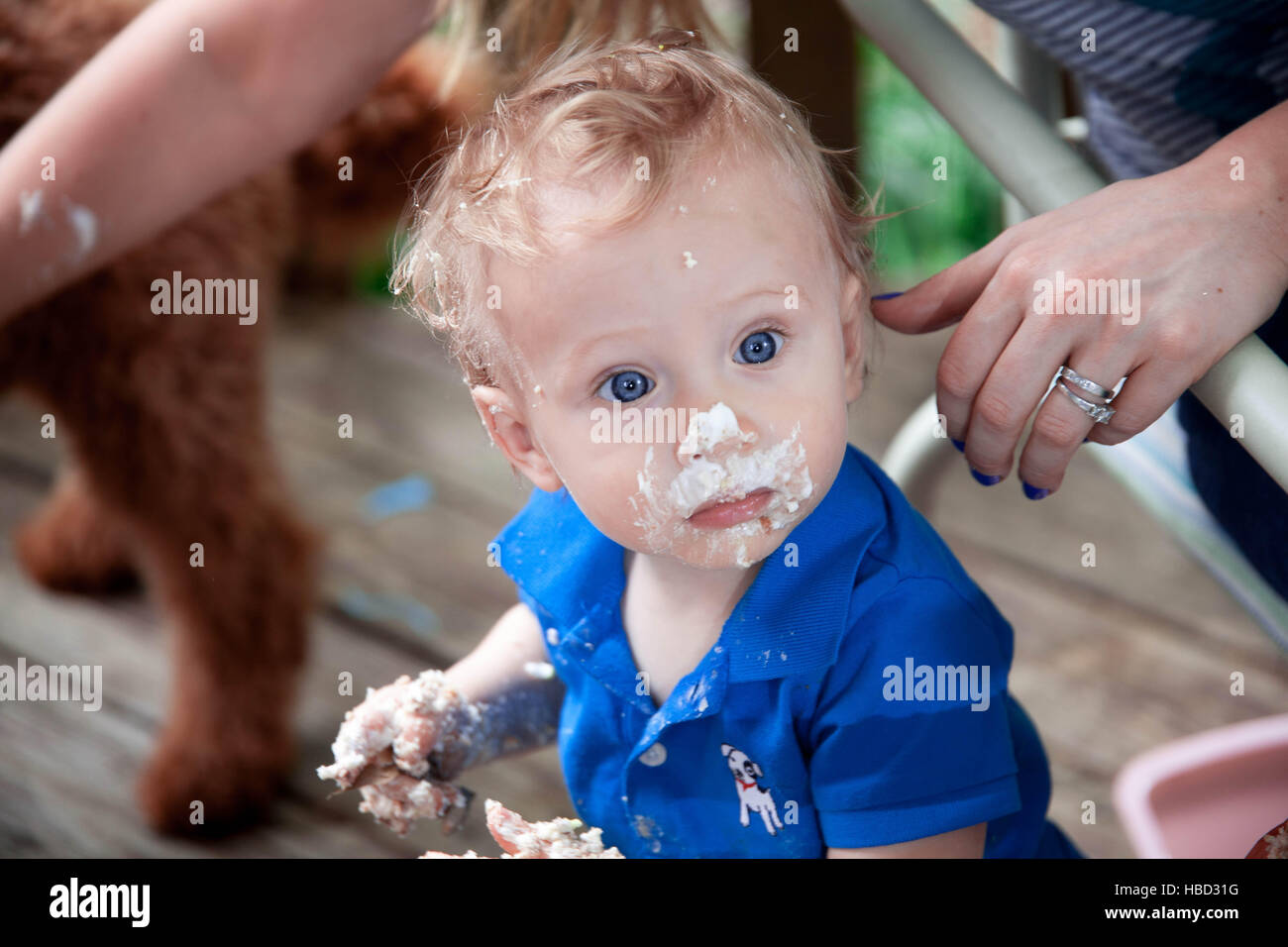 Kaukasische junge feiert seinen 1. Geburtstag, so dass ein Chaos mit Kuchen draußen im Sommer Stockfoto