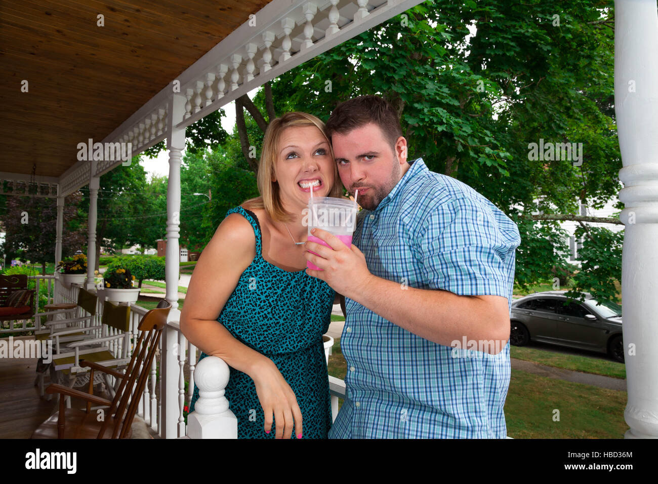 Junges Paar kaukasischen flirten miteinander, Alkohol trinken und Handeln auf einer vorstädtischen Veranda albern Stockfoto