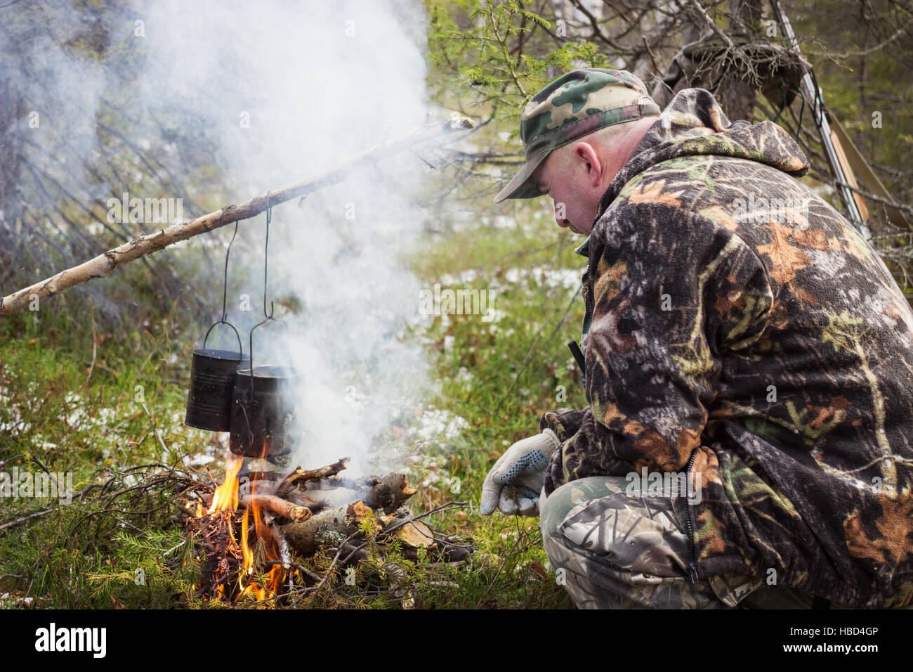 Jäger hat Kochen über dem Lagerfeuer Stockfoto