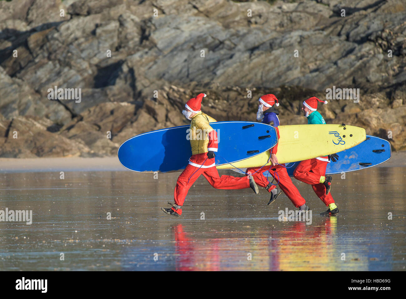 Surfen Santas nehmen an der jährlichen Spendenaktion Santa Surf-Wettbewerb an einem sehr kalten Fistral Strand in Newquay, Cornwall.  VEREINIGTES KÖNIGREICH. Stockfoto