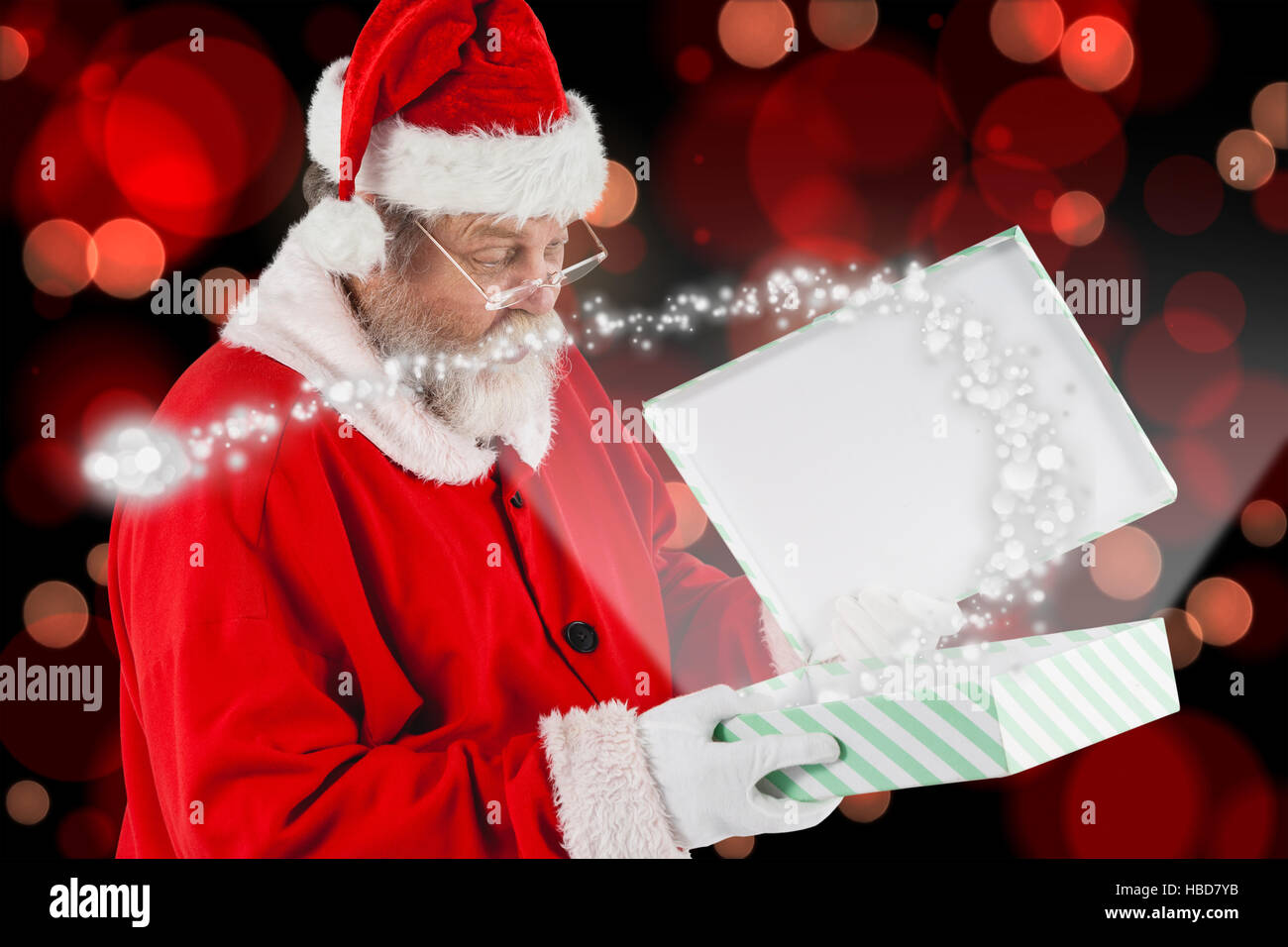 Zusammengesetztes Bild des Weihnachtsmannes betrachten öffnen Geschenkbox Stockfoto