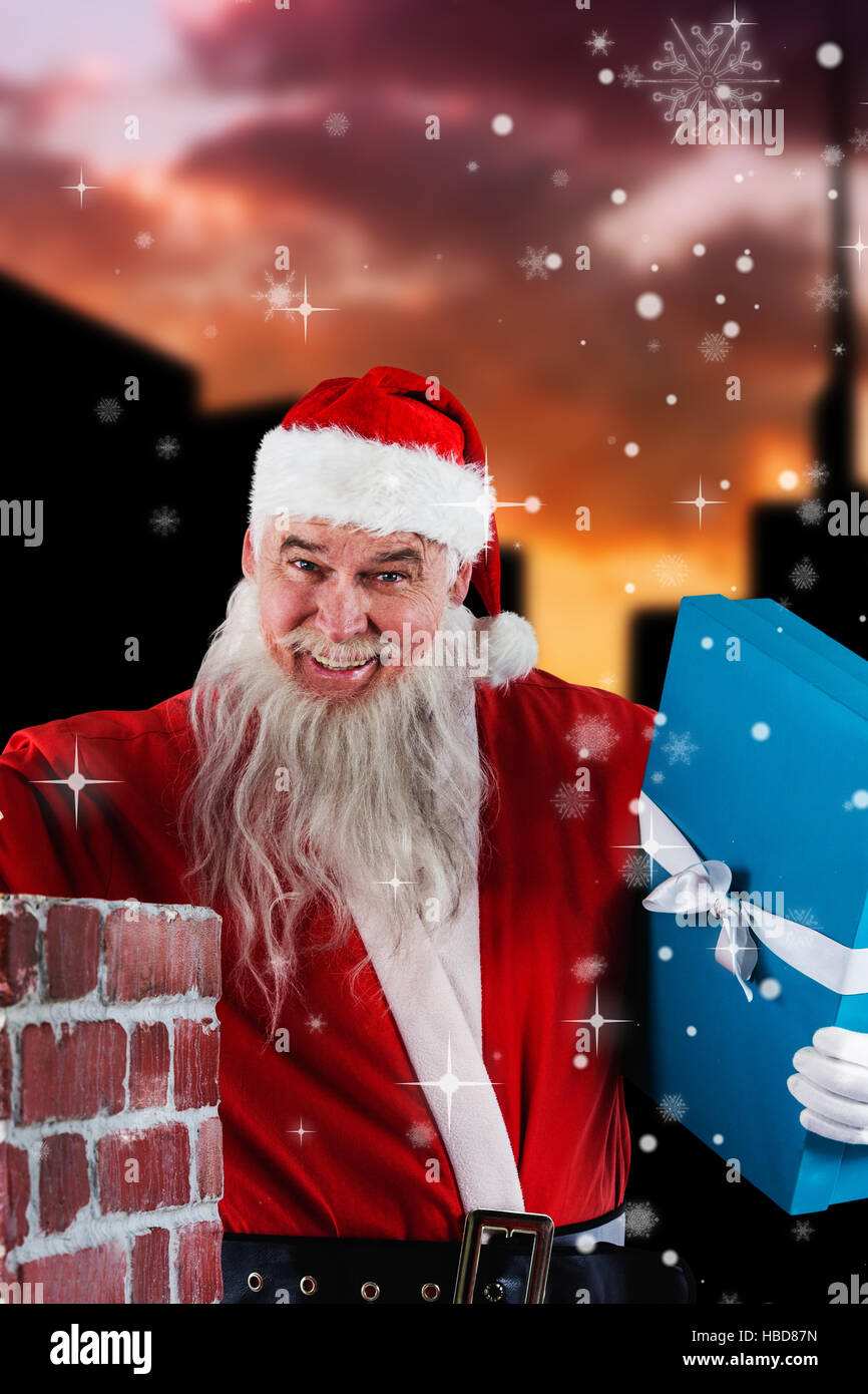 Zusammengesetztes Bild Porträt des Weihnachtsmannes platzieren von Geschenk-Boxen in Schornstein Stockfoto