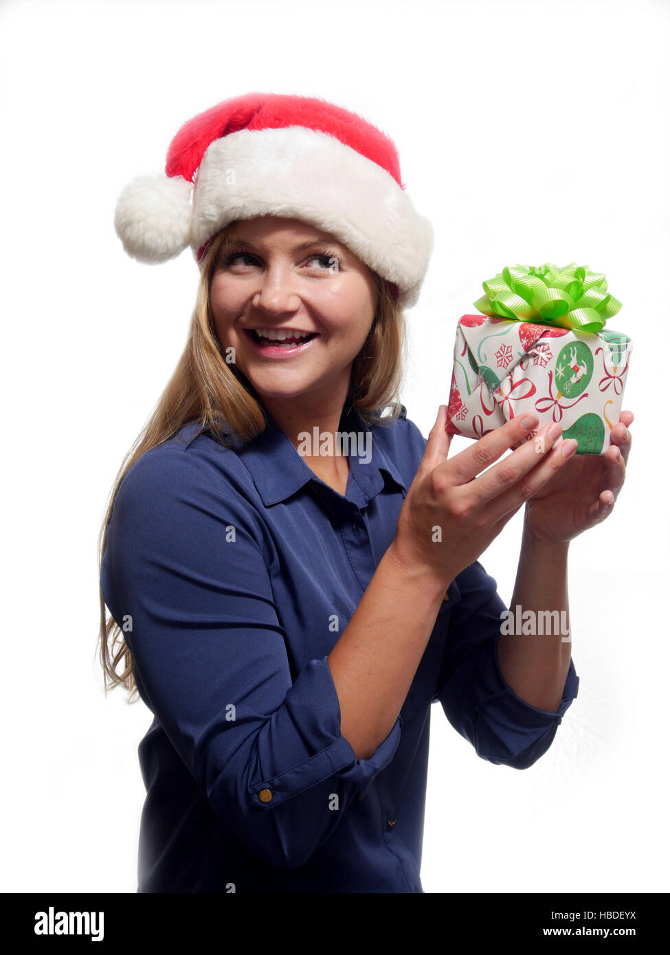 Eine junge Frau hält ein Geschenk zu Weihnachten und das Tragen eines Santa Claus hat Stockfoto