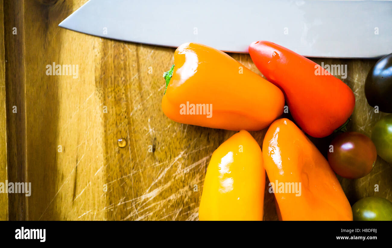 gemischte Paprika und Tomaten auf einem Schneidebrett Stockfoto