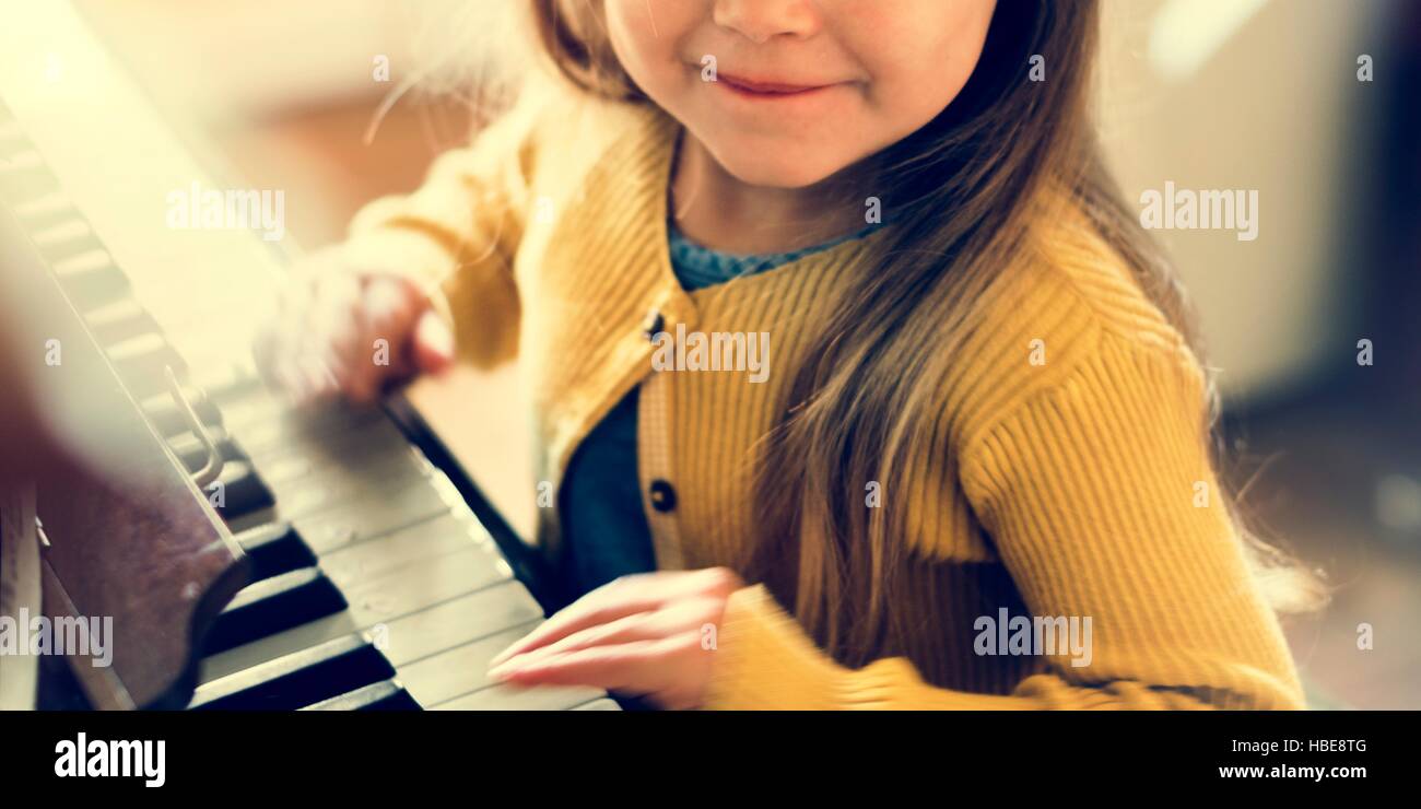 Entzückende niedliche Mädchen spielen Klavier Konzept Stockfoto