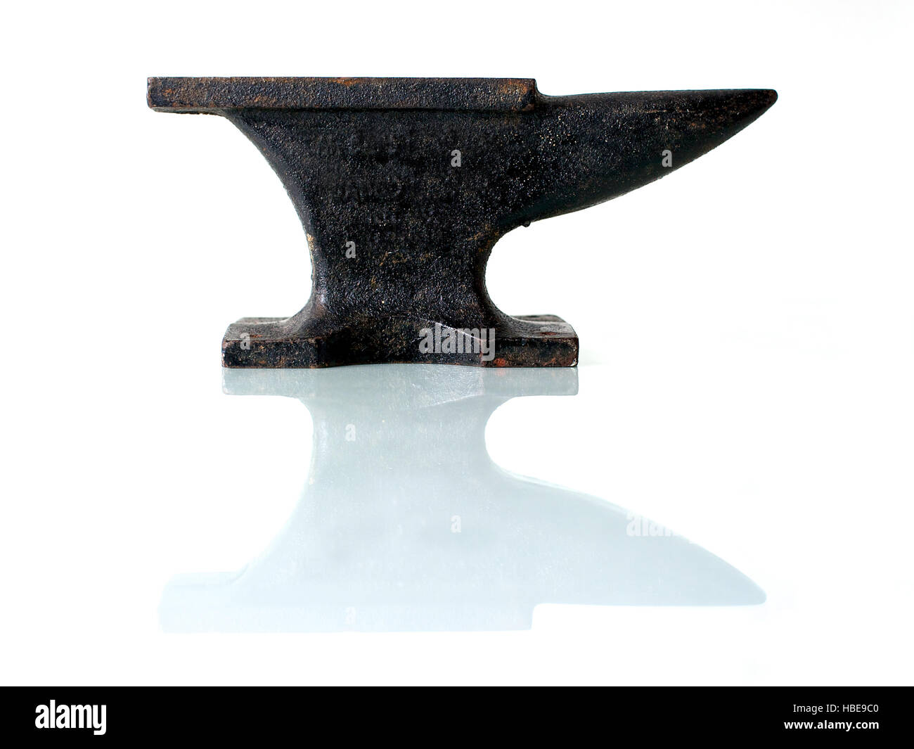 Schmied Werkzeuge, einen alten Amboss auf einer Glasplatte mit weißem Hintergrund. Stockfoto