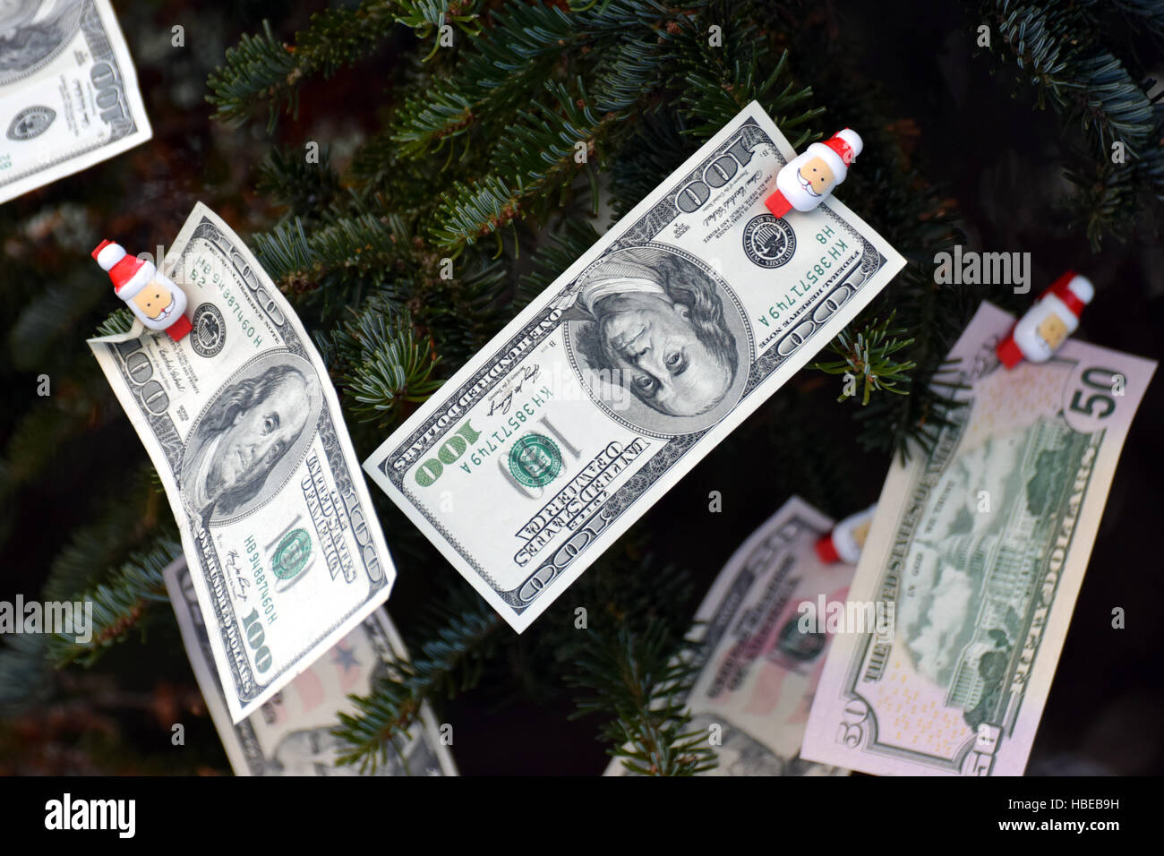 Geld in einen Weihnachtsbaum hängen. Stockfoto