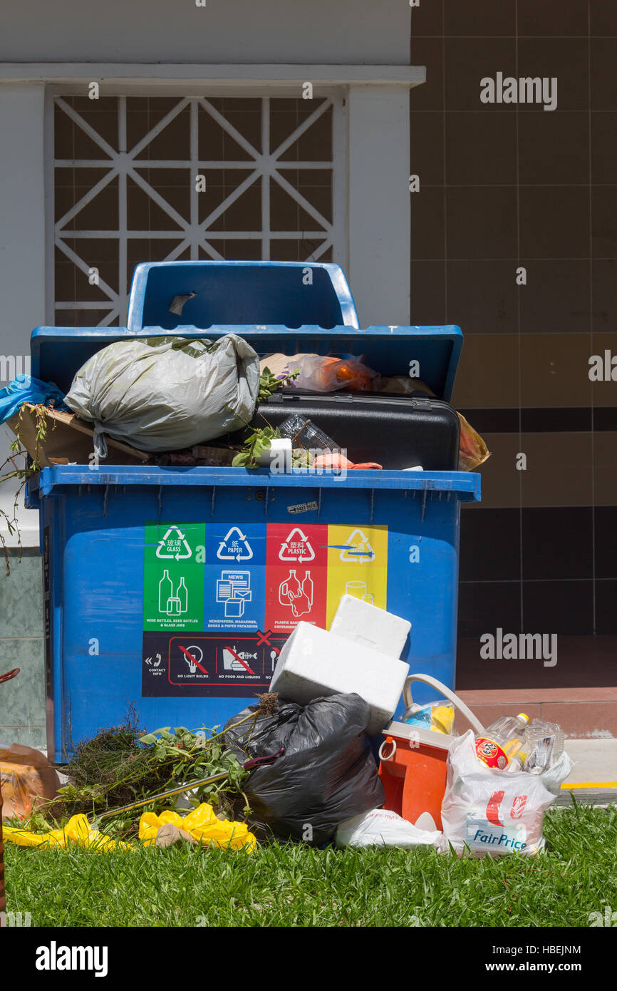 Recyclingbehälter überfüllt mit Müll Stockfoto