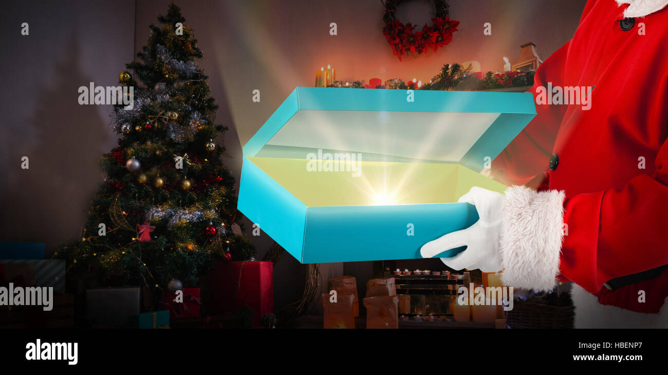 Zusammengesetztes Bild von Santa Claus Geschenk-Box öffnen Stockfoto