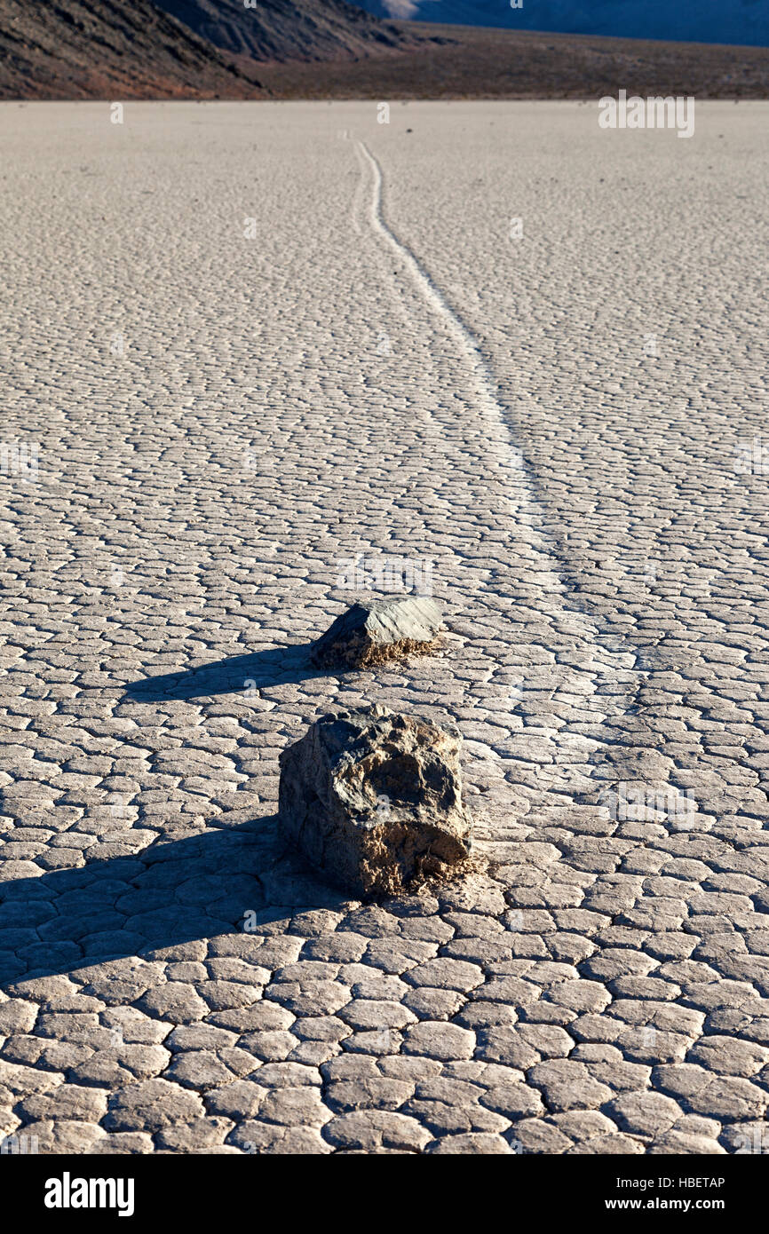 Trail links durch ein paar Felsen auf dem Racetrack Playa in Death Valley Nationalpark Segeln zeugt von den Felsen Bewegung über die Playa. Die R Stockfoto