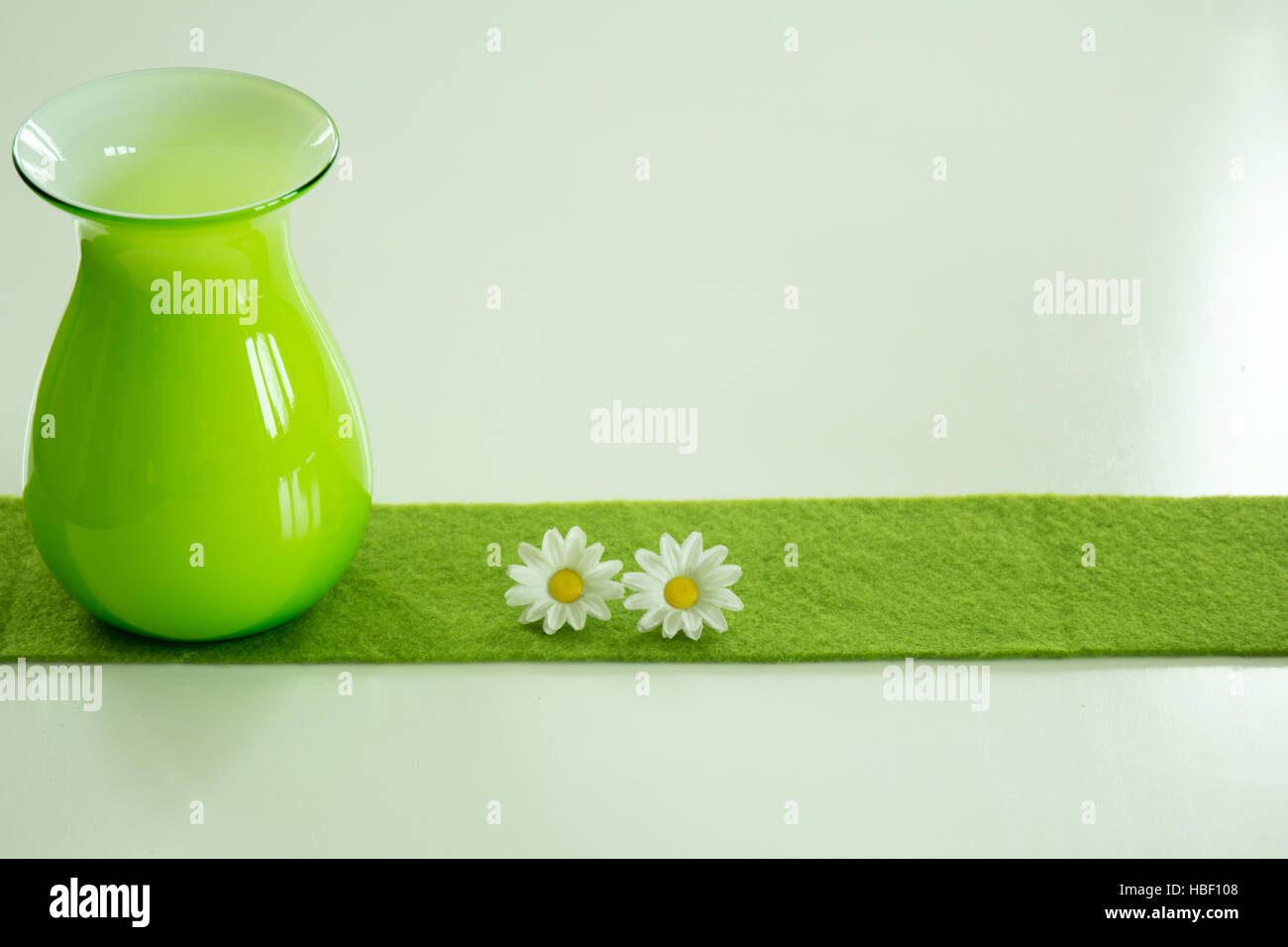 Vase und Daisys auf weißem Grund Stockfoto