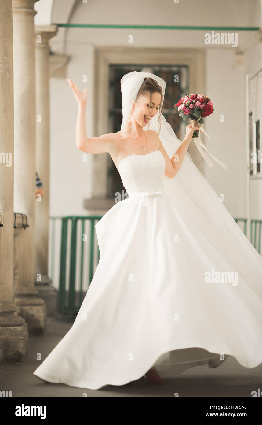Schöne Braut mit Brautstrauß posiert in Altstadt Stockfoto