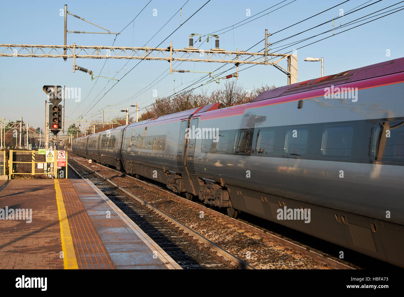 Jungfrau-Züge intercity Zug Beschleunigung Vergangenheit, die obenliegende Elektrizität Drähte auf der Schiene in Liverpool South Parkway Station verfolgen Stockfoto