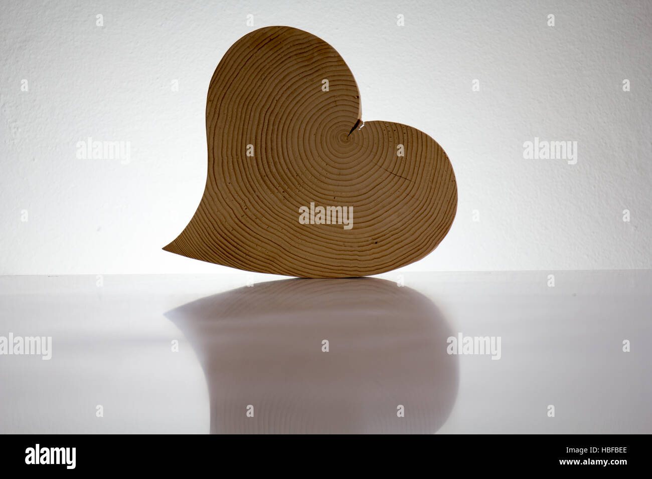 Ein Herz aus Holz vor weißem Hintergrund Stockfoto