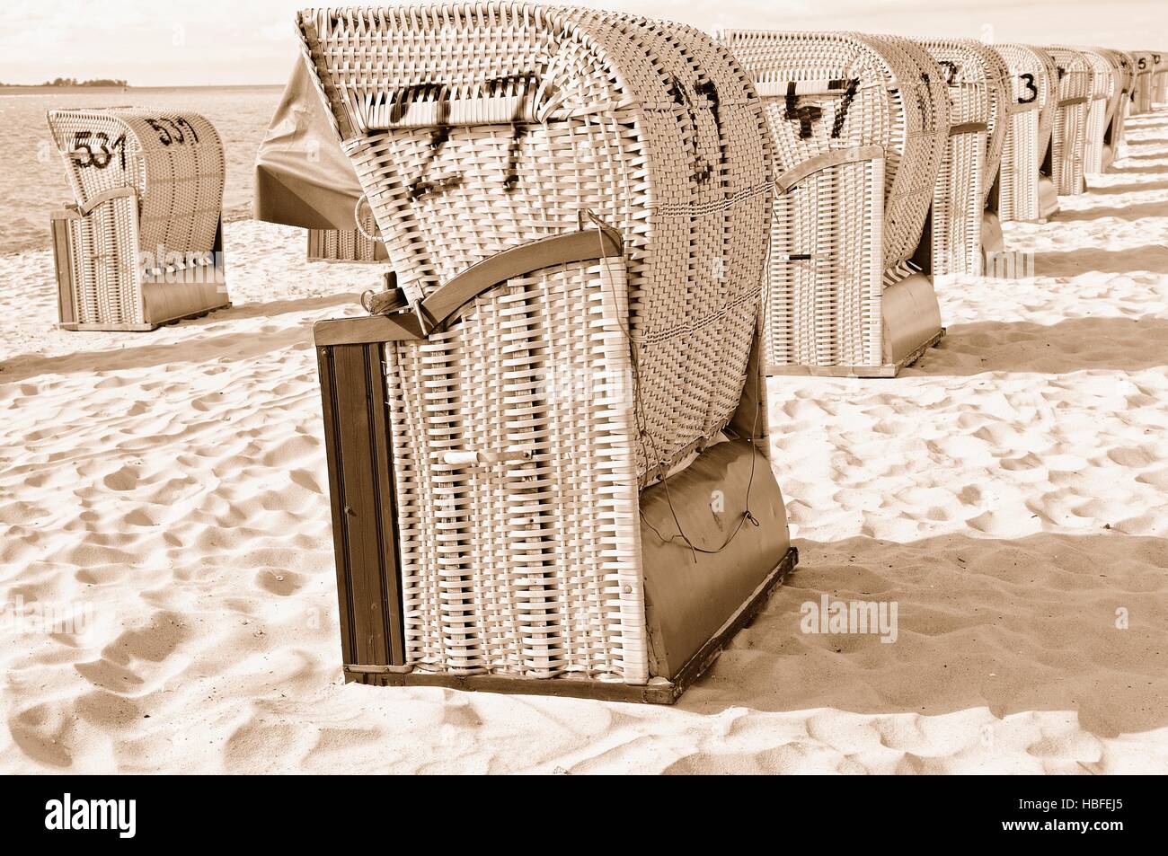 Strandkörbe in Zeile sepia Stockfoto