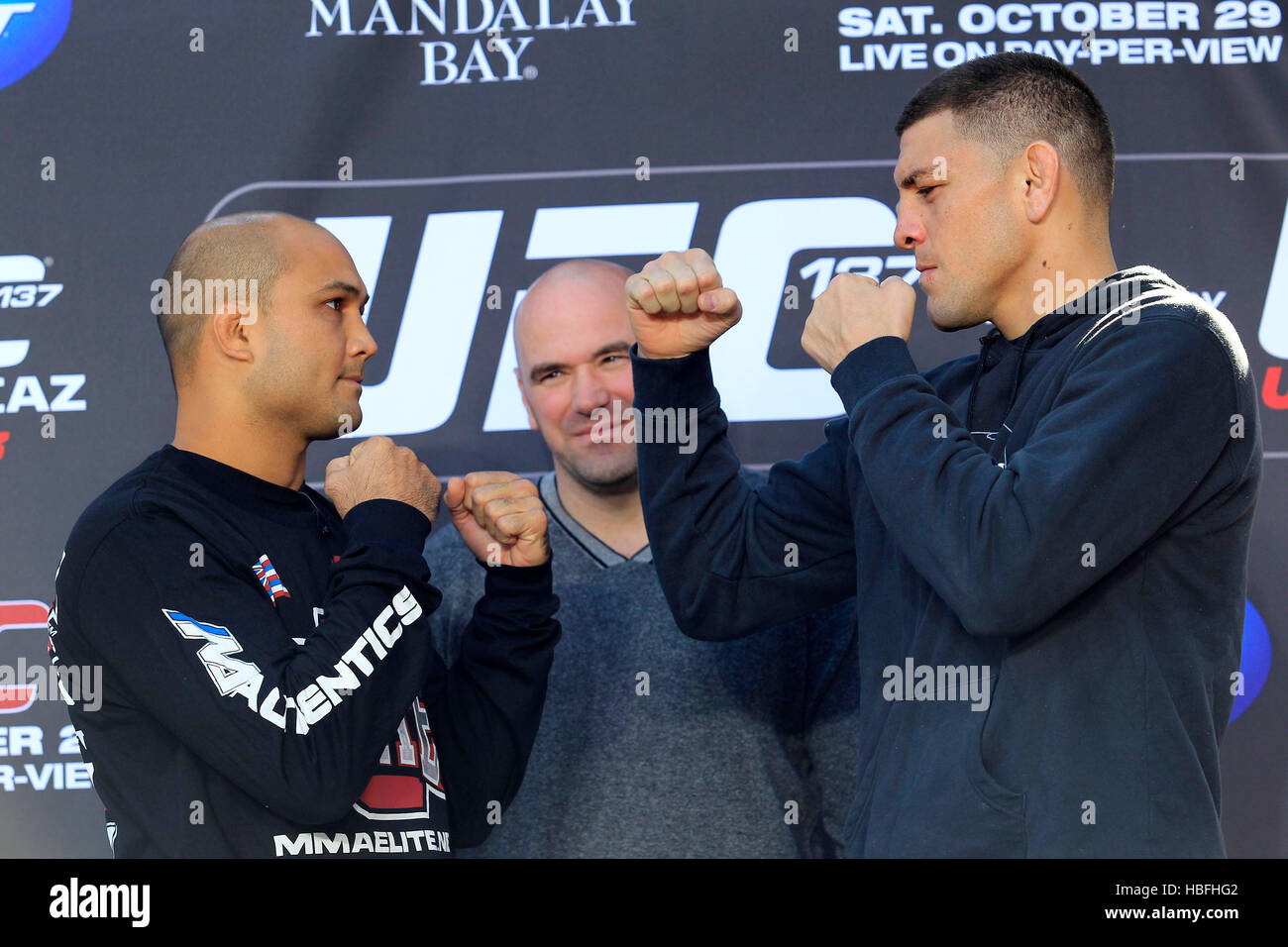 UFC-Kämpfer BJ Penn, links, und Nick Diaz posieren für Fotos, wie UFC-Präsident Dana White im Hintergrund während einer Pressekonferenz für UFC 137 in Las Vegas, Nevada auf Donnerstag, 27. Oktober 2011 blickt auf. Foto von Francis Specker Stockfoto