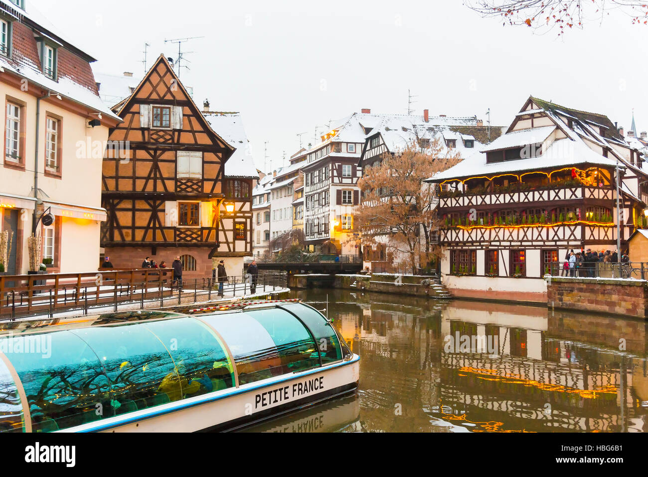 Ausflugsschiff mit Touristen entlang dem Fluss Ill Petite France zur Weihnachtszeit, Straßburg, Elsass, Bas-Rhin-Frankreich Stockfoto