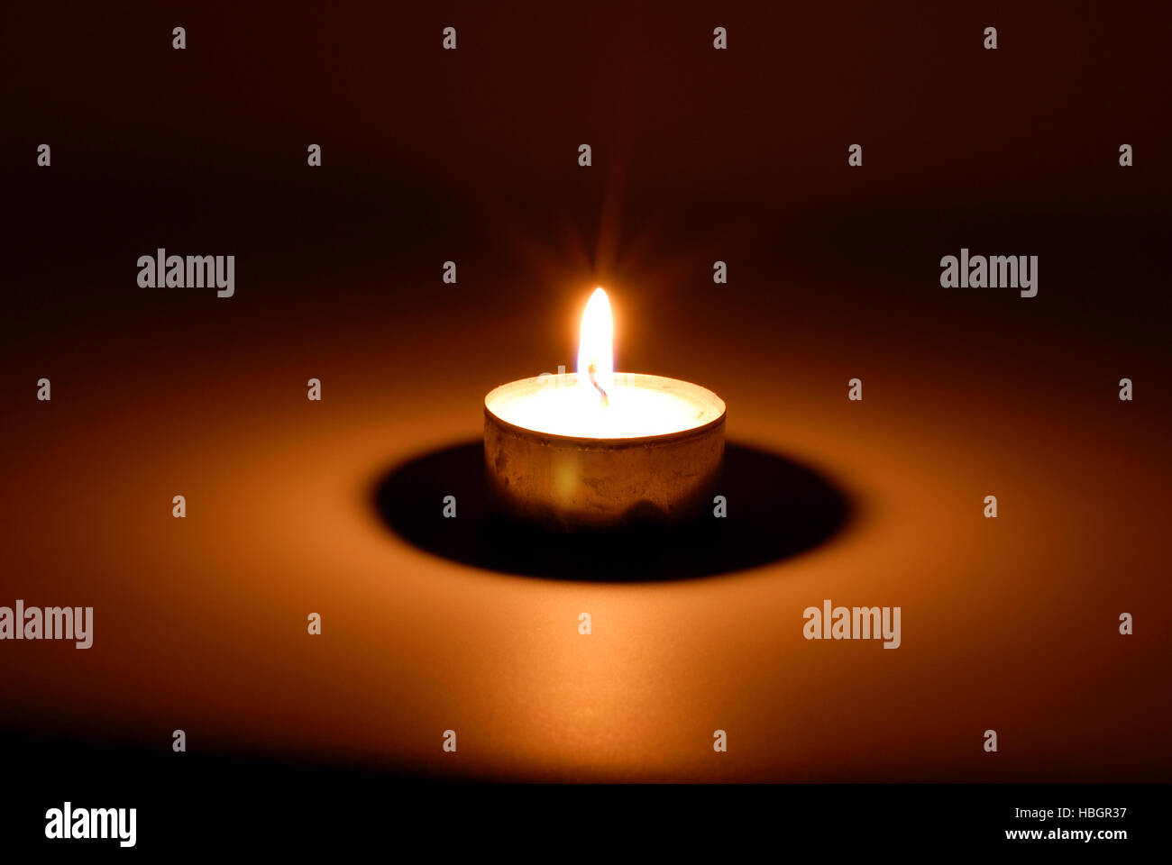 Brennende Kerze in der Dunkelheit Stockfoto