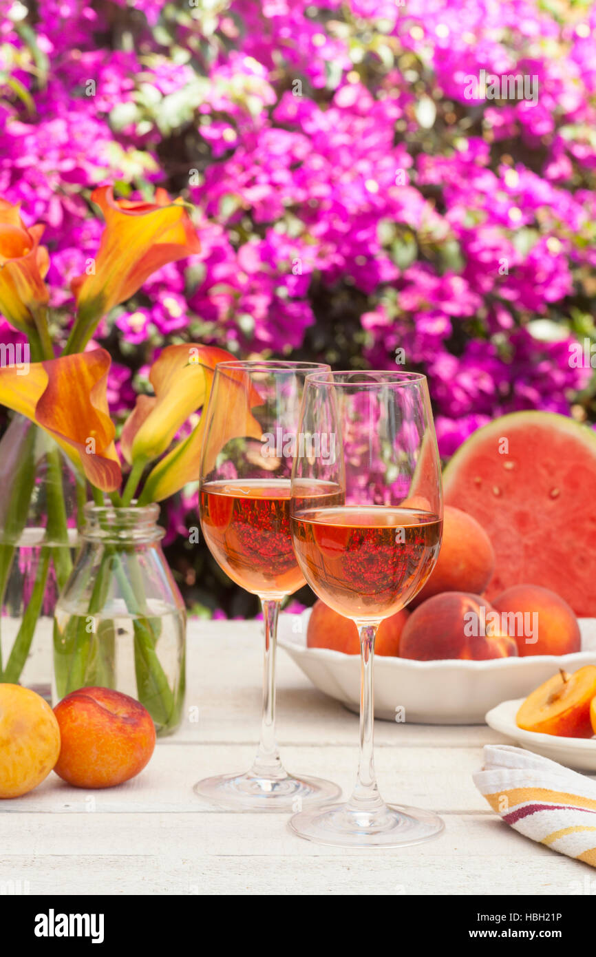 Brille von Roséwein, Pfirsichen, Pflaumen und Wassermelone bei einem Picknick im Sommer Stockfoto