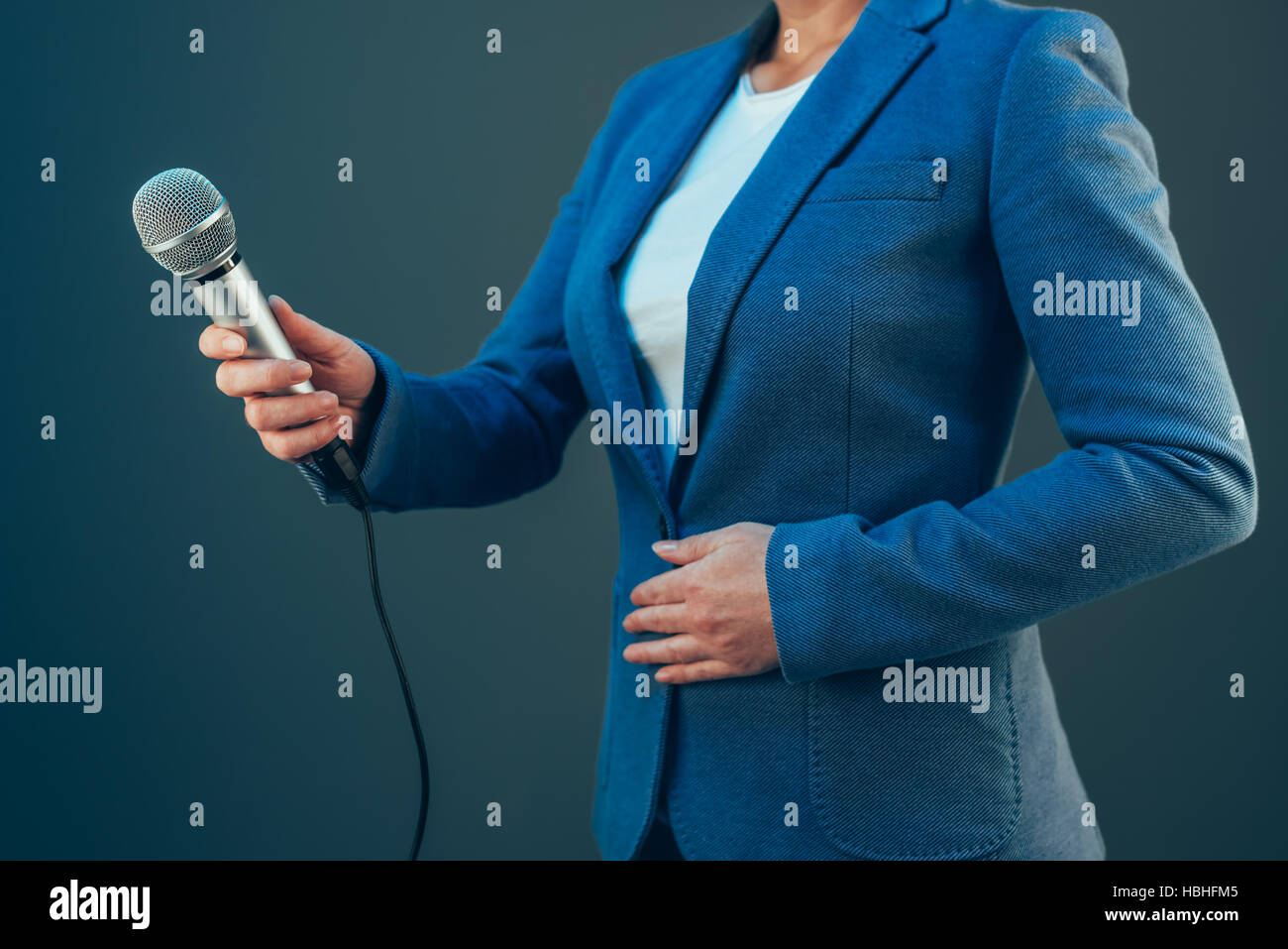 Elegante Journalistin Durchführung von Business-Interview oder Pressekonferenz, mit Mikrofon hand Stockfoto