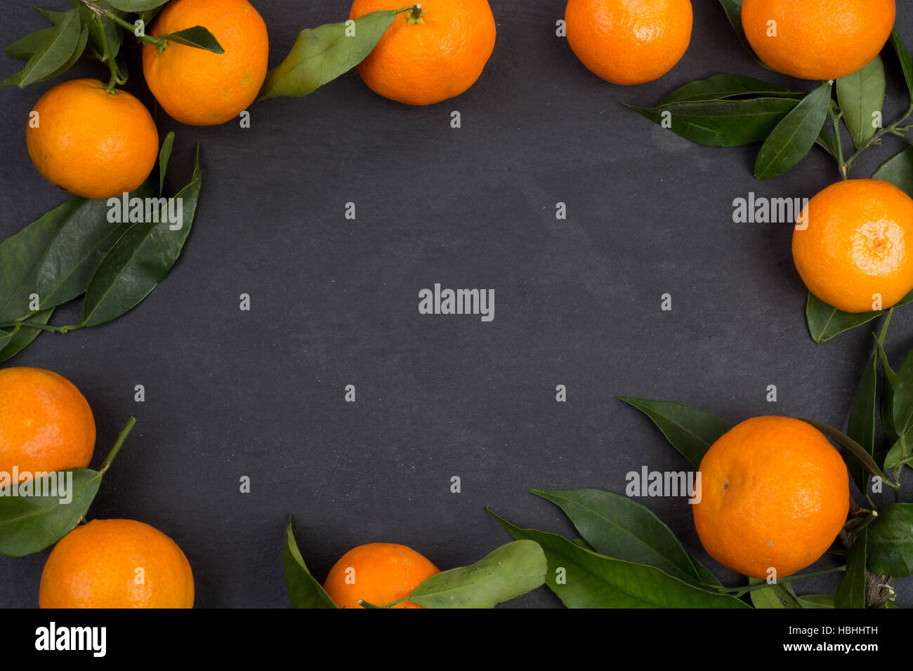 Dunkle Schiefer Tisch mit Mandarine Früchten für den Hintergrund mit Textfreiraum Stockfoto