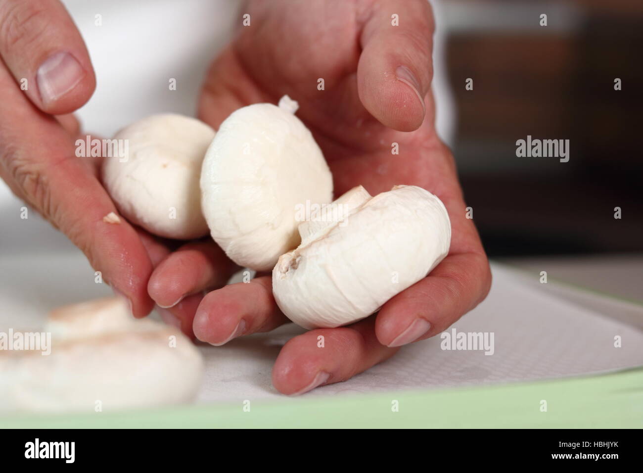Koch hält Champignons in der hand. Huhn, Käse und Lauch-Paket-Serie zu machen. Stockfoto