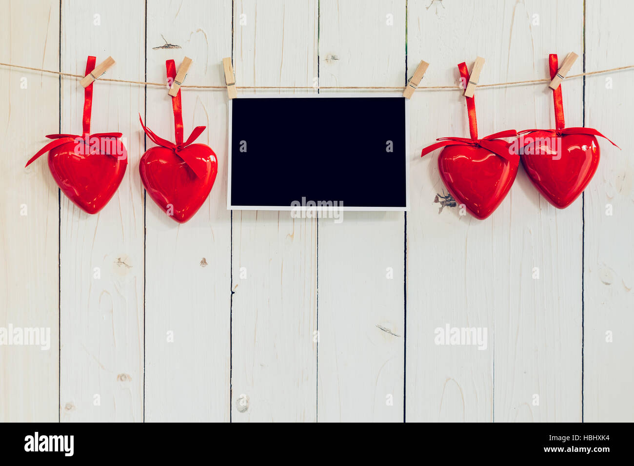 Foto Rahmen leer und roten Herzen hängen weiße Holz Hintergrund mit Raum Stockfoto