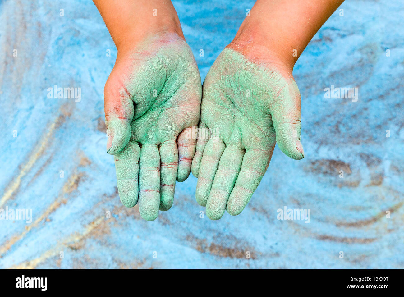 Kind zeigt grüne Hände mit Kreide Stockfoto