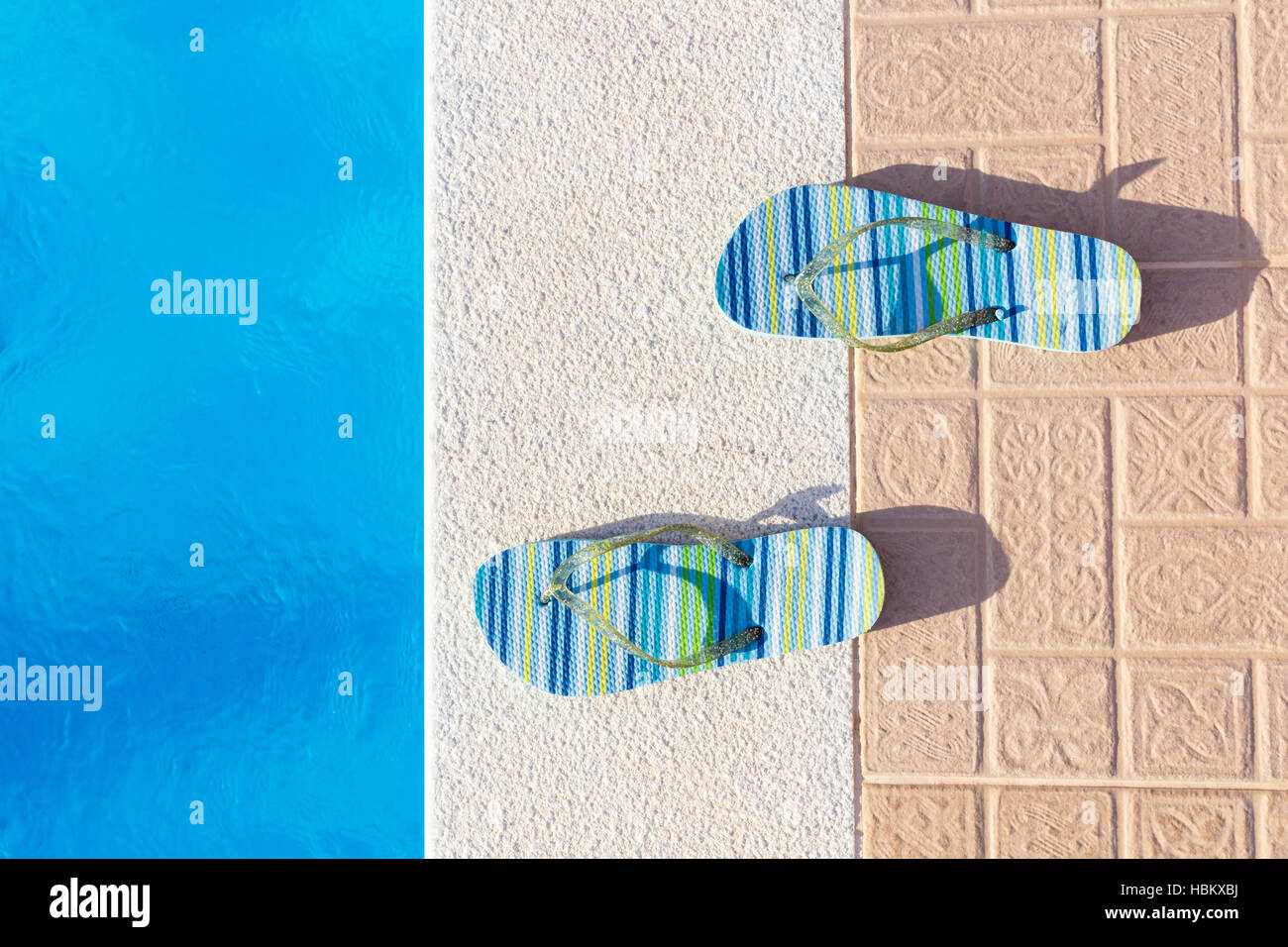 Pantoffeln am Rand des Swimming pool Stockfoto