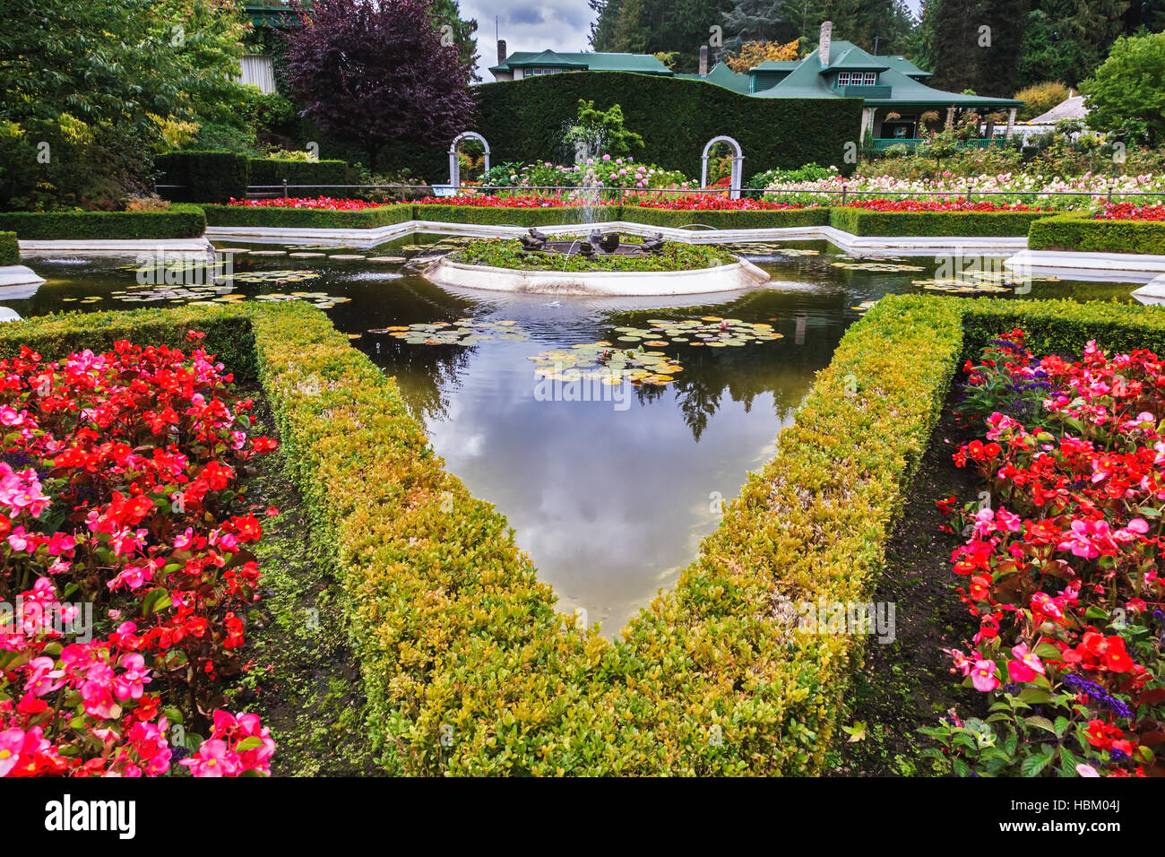 Exquisite Brunnen unter den Blumenbeeten Stockfoto