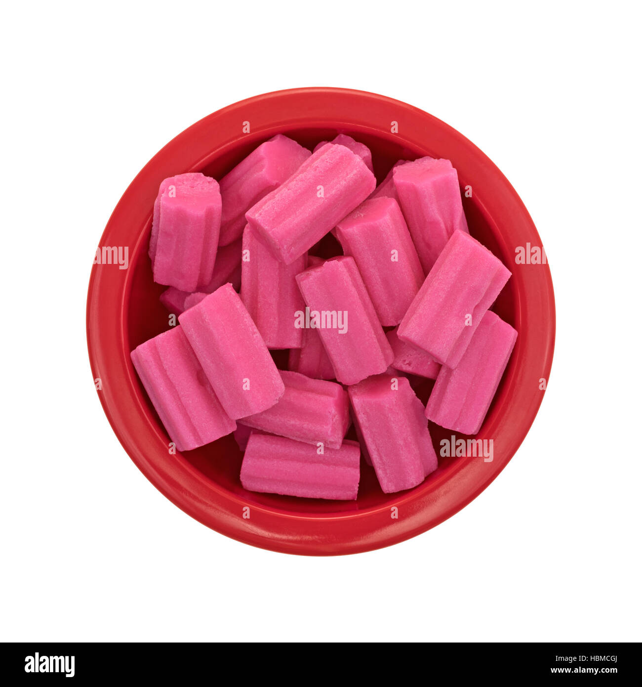 Draufsicht auf eine kleine rote Schüssel gefüllt mit rosa Kaugummi isoliert auf einem weißen Hintergrund. Stockfoto
