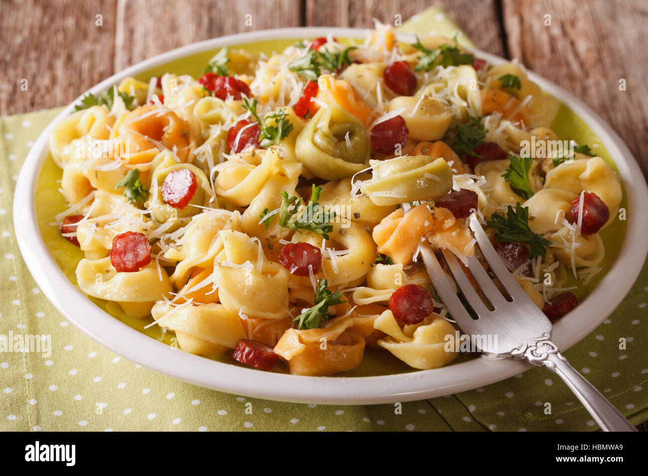 Traditionellen bunten Tortellini mit Parmesan-Käse und Wurst Nahaufnahme auf einer Platte. horizontale Stockfoto