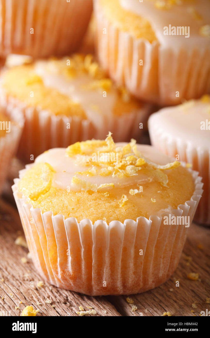 frisch gebackenes Zitronen-Muffins mit Zuckerguss Makro auf dem Tisch. Vertikal Stockfoto