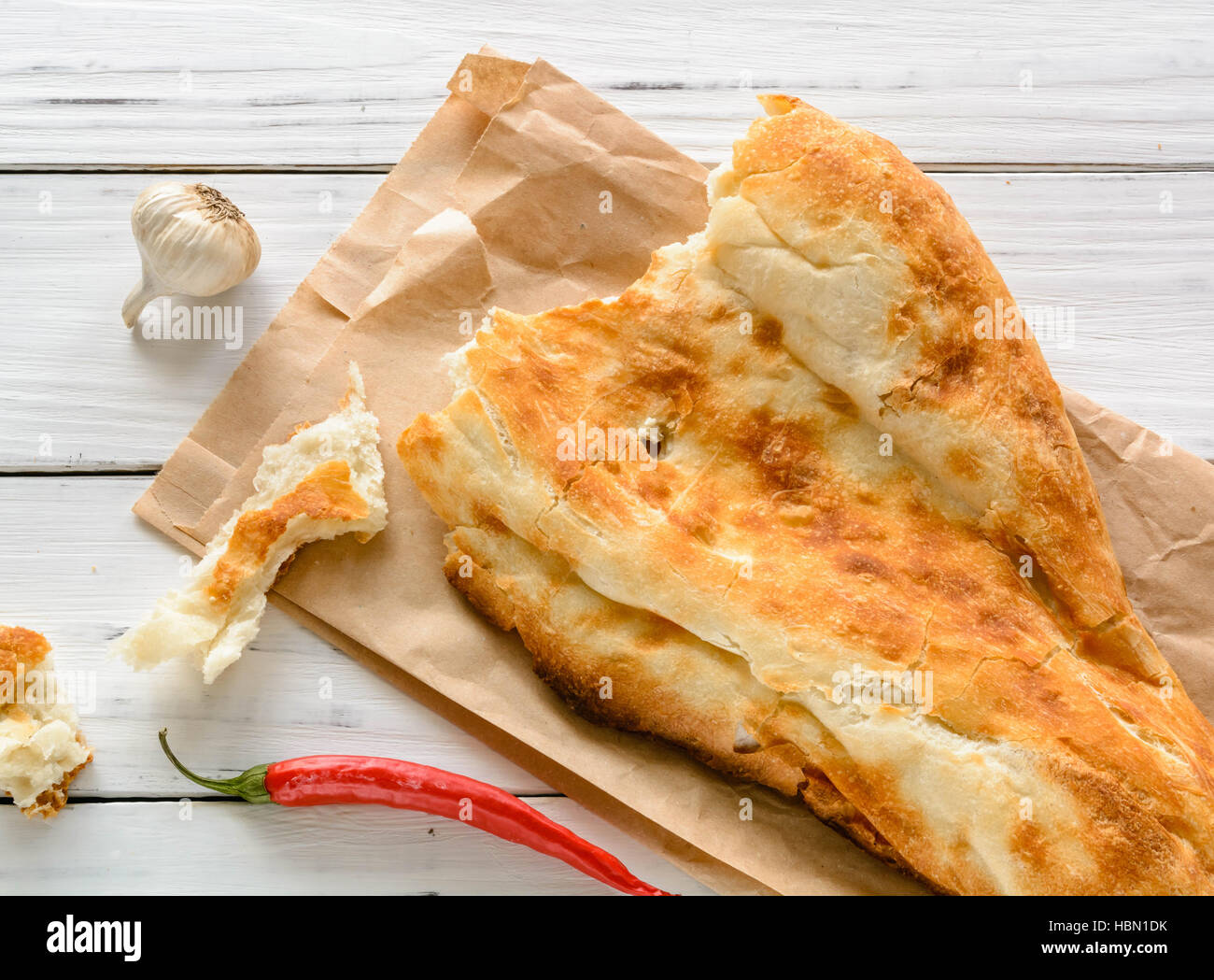 halbes Fladenbrot kaukasischen, liegend auf einem Schneidebrett gebrochen. Hellen Holz Hintergrund. Stockfoto