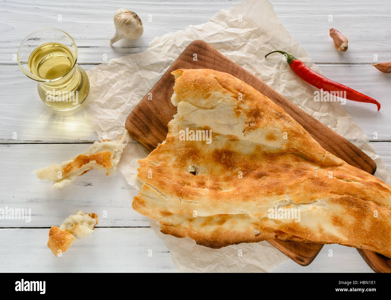 halbes Fladenbrot kaukasischen, liegend auf einem Schneidebrett gebrochen. Hellen Holz Hintergrund. Stockfoto