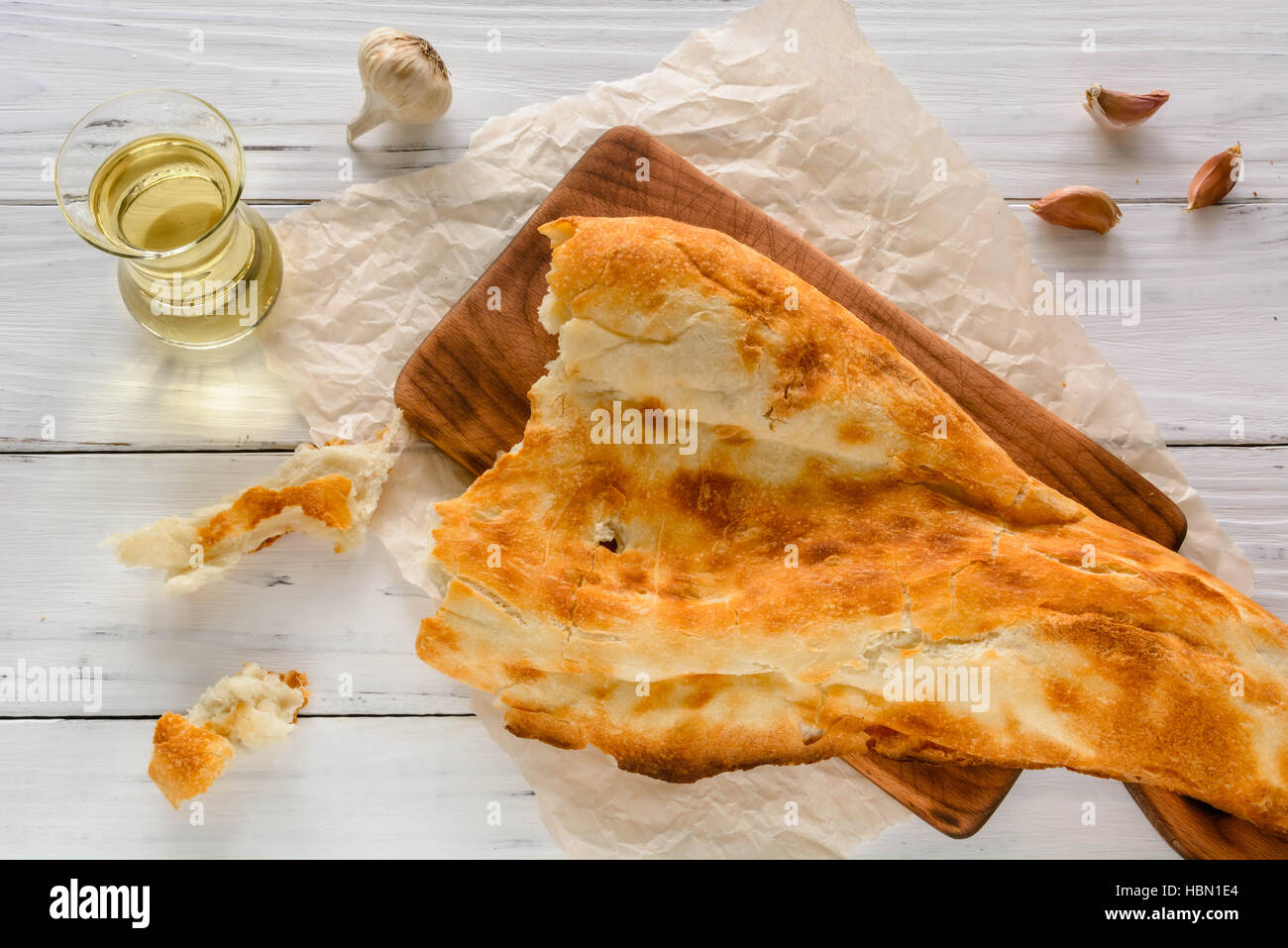 halbes Fladenbrot kaukasischen, liegend auf einem Schneidebrett gebrochen. Hellen Holz Hintergrund. Stockfoto