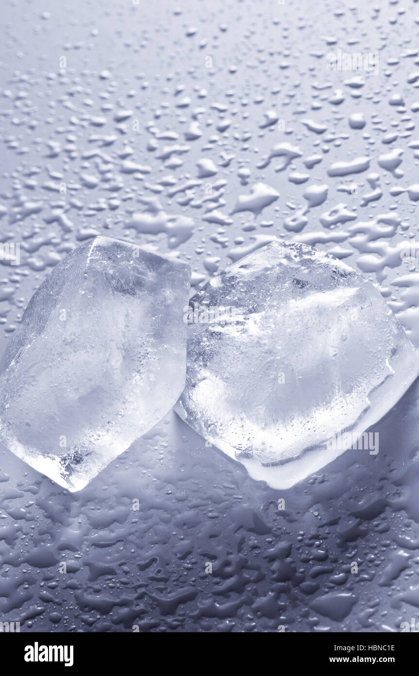 zwei Eiswürfel auf nassem Untergrund Stockfoto