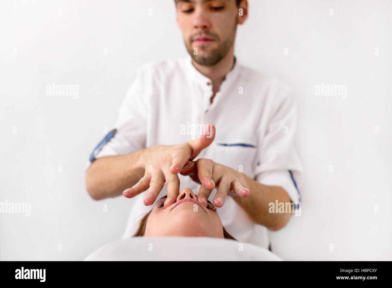 Master massage an Client auf weißem Hintergrund Stockfoto
