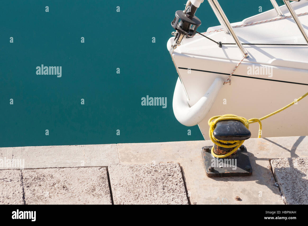 Fragment des weißen Yacht Bogen geparkt in der Nähe von Betonpfeiler Stockfoto